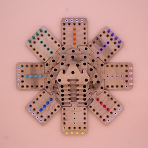 May include: A wooden game board with eight sections, each with a different colored peg pattern. The board is made of light wood and has a natural finish. The pegs are made of plastic and are in the colors red, orange, yellow, green, blue, purple, and white.
