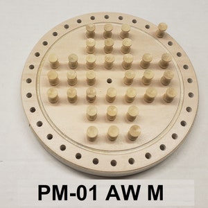 May include: A wooden game board with a circular shape and a pattern of holes around the edge. The board has a central area with 49 small wooden pegs arranged in a diamond pattern. The text "PM-01 AW M" is printed below the board.