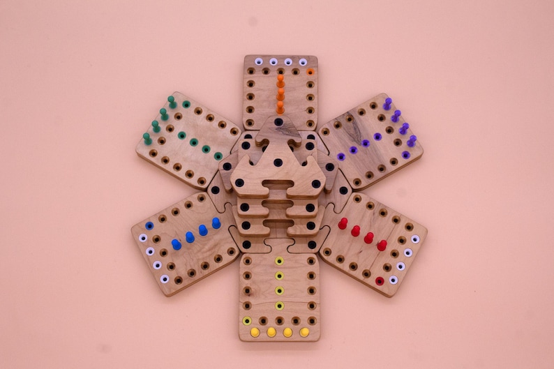 May include: A wooden game board with six hexagonal sections, each with a different colored peg pattern. The sections are arranged in a circle around a central piece. The pegs are red, blue, green, yellow, orange, and purple.