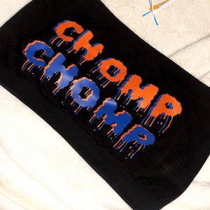 May include: Black tube top with the words "CHOMP CHOMP" printed in orange and blue dripping letters.