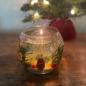 shalant holiday gel candles Pine and snow candles made with pine garland pine cones and sugar snow in clear gel wax. jelly candle in a glass bowl. These candles have a refillable glass votive in the center. Gel wax is scented with a pine balsam scent