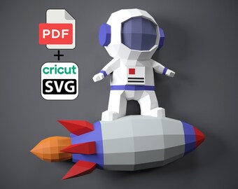 May include: A white and blue geometric astronaut figure standing on a gray, red, and orange rocket. The image includes a PDF icon and a Cricut SVG icon, suggesting a digital craft project.