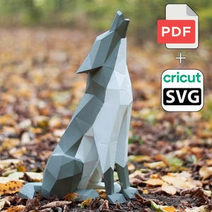 May include: A geometric papercraft wolf sculpture in shades of gray and white, posed in a howling position. The image includes a PDF and SVG file icon, suggesting a digital template for crafting. The wolf is set against a backdrop of autumn leaves.