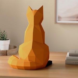 Pode incluir: Uma escultura geom&eacute;trica de uma raposa laranja, vista por tr&aacute;s, est&aacute; sobre uma superf&iacute;cie de madeira. A raposa tem um design poligonal e uma cauda longa e curva. A escultura &eacute; um item decorativo, adequado para decora&ccedil;&atilde;o de casa.