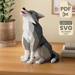 May include: A geometric papercraft wolf sculpture in shades of gray and white, with a red mouth, sits on a wooden surface. The wolf is howling upwards. The image also includes PDF and SVG cut files.