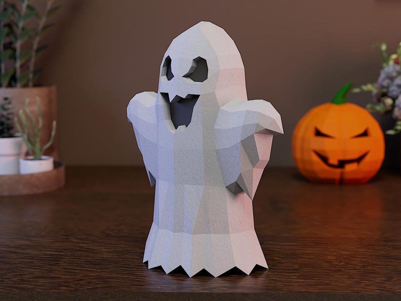 May include: A low-poly white ghost figurine with a jagged, geometric surface texture. The ghost features dark, triangular eye cutouts and a wide, open mouth with sharp, pointed teeth, creating a stylized, angular appearance for this spooky decor.