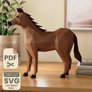 Pode incluir: Escultura de cavalo geométrico castanho. O cavalo de papel está sobre uma superfície de madeira. A imagem também inclui um ícone de arquivo PDF e Cricut SVG.