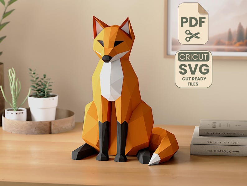 Pode incluir: Uma escultura geom&eacute;trica de raposa em papel, em tons de laranja, branco e preto, sentada sobre uma superf&iacute;cie de madeira. A raposa tem um peito branco e uma cauda espessa. A imagem tamb&eacute;m inclui o texto "PDF" e "CRICUT SVG CUT READY FILES".