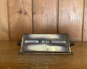 May include: A brass desk calendar with a date of Tuesday, September 17th.