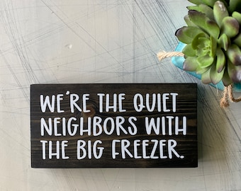 We're the quiet neighbors with the big freezer. - mini wood sign