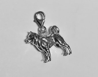 May include: Silver charm of a husky dog in a standing position. The charm has a loop at the top for attaching to a bracelet or necklace.