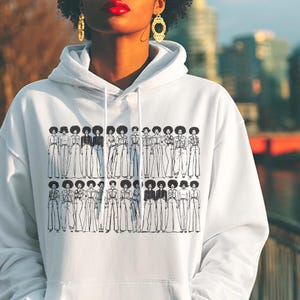 May include: A white hooded sweatshirt featuring a black graphic print of two rows of illustrated figures with afro hairstyles, each wearing different outfits. The hoodie has long sleeves, a front pocket, and white drawstrings at the neckline.