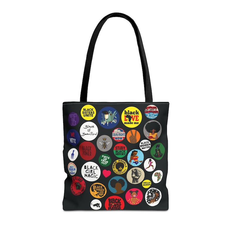May include: Black tote bag with black handles. The bag is covered in colorful circular graphics with phrases like "Black Girl Magic," "Black Love," and "Black Women Matter." The bag is made of a durable material.
