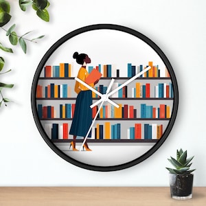 Puede incluir: Reloj de pared redondo con marco negro. La esfera muestra a una persona leyendo en una biblioteca, con una blusa amarilla y una falda azul. Estanterías llenas de libros coloridos forman el fondo.