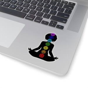 May include: A black silhouette of a person sitting in a yoga pose with seven colorful chakras along the spine. The chakras are in the colors of the rainbow, starting with red at the base and ending with violet at the crown.