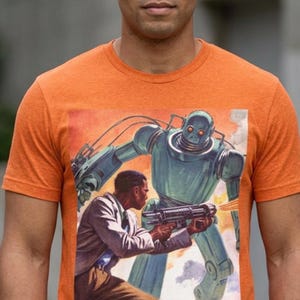 May include: Orange t-shirt featuring a retro sci-fi illustration of a man firing a weapon at a large teal robot. The artwork has a vintage comic book style with a fiery orange and red background.