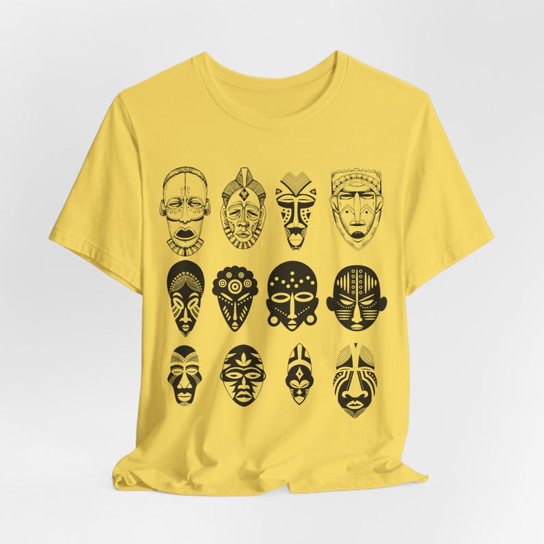 May include: A yellow t-shirt with a black and white print of 12 African tribal masks.