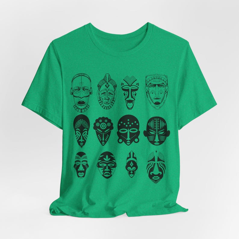May include: A green t-shirt with a black and white design of 12 African tribal masks. The masks are arranged in a grid pattern.