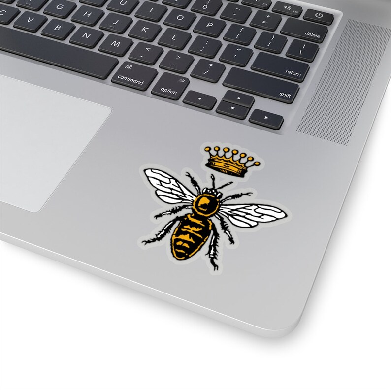 Puede incluir: Una abeja negra y amarilla con alas blancas que lleva una corona dorada. La abeja est&aacute; en una ilustraci&oacute;n de estilo vintage.