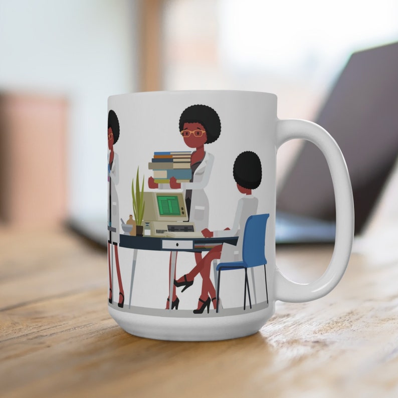 K&ouml;nnte beinhalten: Wei&szlig;e Keramiktasse mit einer bunten Illustration von drei Frauen, die in einem B&uuml;ro arbeiten. Die Frauen tragen wei&szlig;e Laborkittel und haben dunkle Haut und schwarze Haare. Eine Frau h&auml;lt einen Stapel B&uuml;cher, eine andere sitzt an einem Schreibtisch und benutzt einen Computer, und die dritte steht neben dem Schreibtisch. Die Tasse hat einen gro&szlig;en Griff.