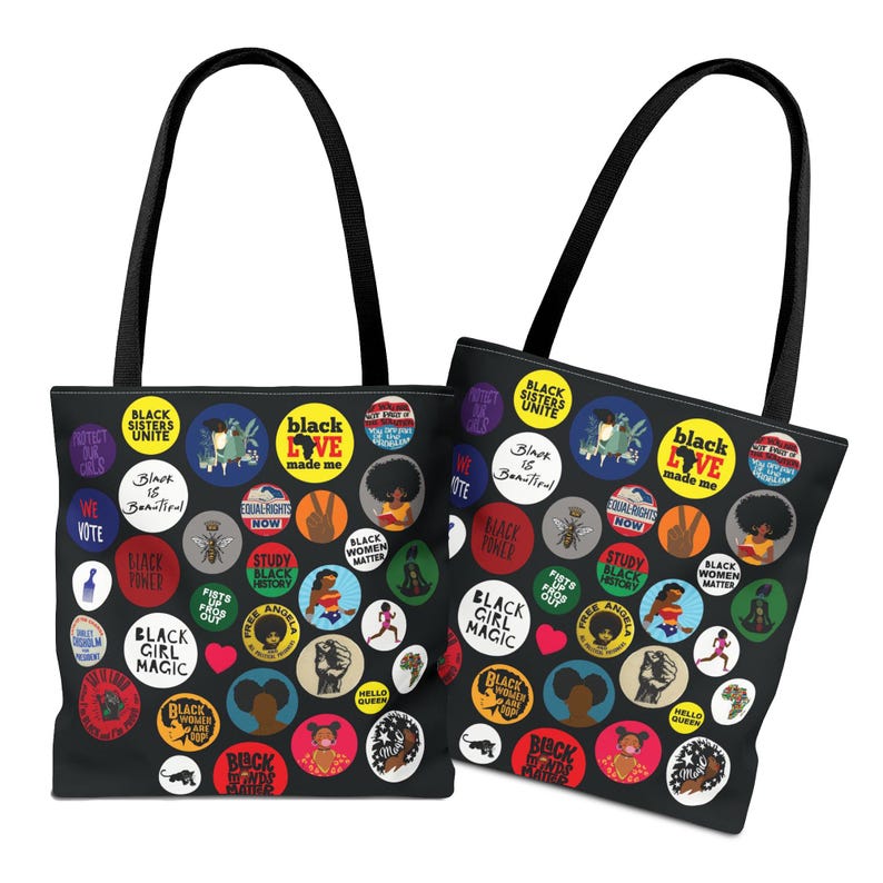 May include: Two black tote bags with black handles. The bags are covered in colorful circular designs with text and illustrations, including phrases like "Black Sisters Unite" and "Black Girl Magic."