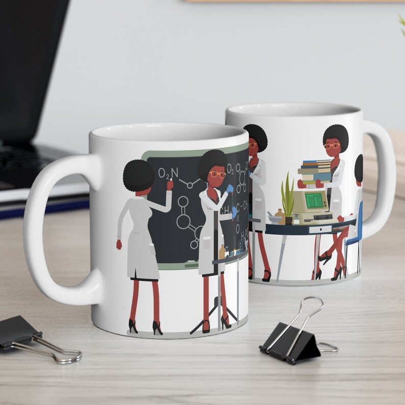 K&ouml;nnte beinhalten: Wei&szlig;e Keramiktasse mit einer bunten Illustration von vier Frauen in Laborkitteln, die in einem wissenschaftlichen Labor arbeiten. Die Tasse hat einen schwarzen Henkel und die Illustration enth&auml;lt eine Tafel mit der chemischen Formel O:N.