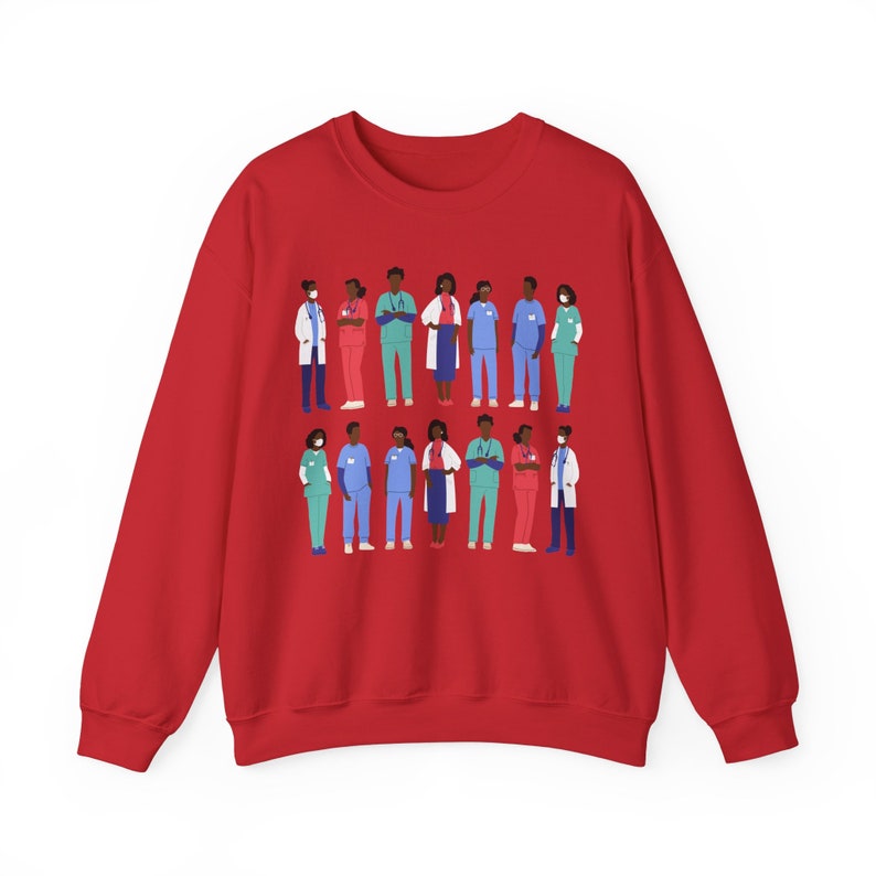 May include: Red sweatshirt with a graphic of a diverse group of healthcare workers wearing scrubs and masks. The graphic is centered on the sweatshirt.