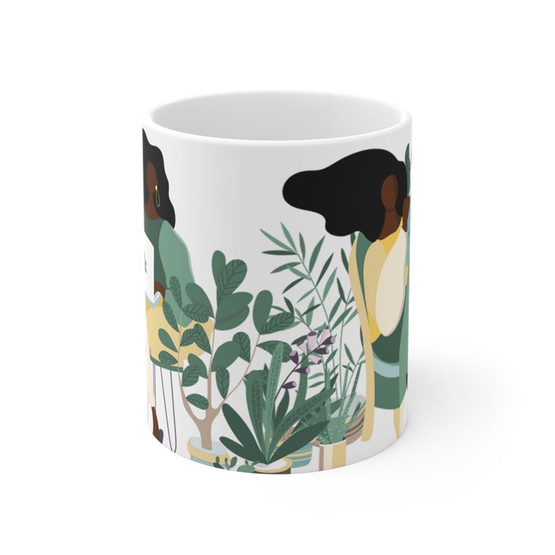 May include: White ceramic mug with a colorful illustration of two women standing in front of potted plants. The women have dark skin and long black hair. The plants are green and have flowers.