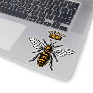 Puede incluir: Una abeja negra y amarilla con alas blancas lleva una corona dorada. La abeja est&aacute; en una ilustraci&oacute;n de estilo vintage.