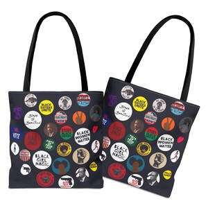 May include: Two black tote bags with black handles. The bags are covered in colorful circular graphics with text like "Black Sisters Unite," "Black Girl Magic," and "Black Women Matter." The graphics include portraits and illustrations.