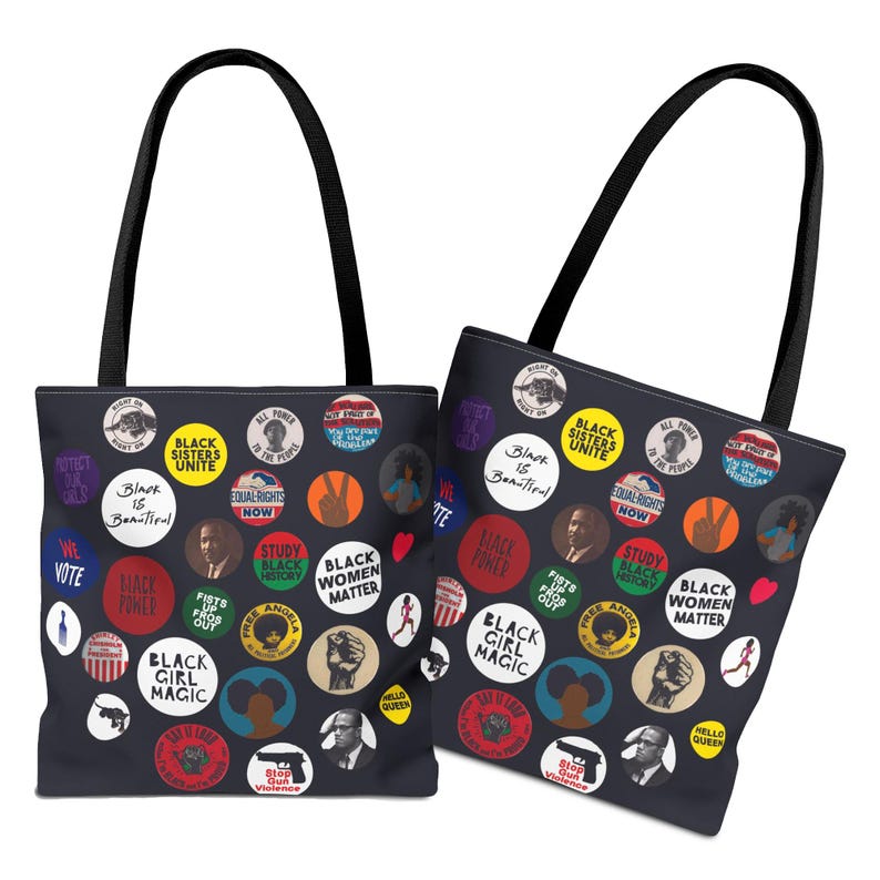 May include: Two black tote bags with black handles. The bags are covered in colorful circular graphics with text like "Black Sisters Unite," "Black Girl Magic," and "Black Women Matter." The graphics include portraits and illustrations.