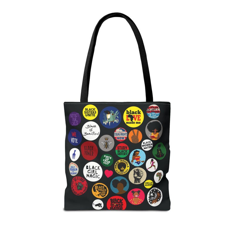 May include: Black tote bag featuring a collage of colorful circular designs with text and illustrations. The designs include phrases like "Black Girl Magic," "Black Love," and "Black Women Matter." The bag has a black handle.