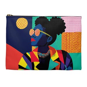 May include: A zippered pouch featuring a vibrant pop art illustration of a person wearing sunglasses and a colorful jacket. The design includes a yellow sun, geometric patterns, and a dark blue background.