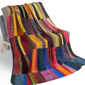 Può includere: Una trapunta colorata a patchwork con una varietà di strisce e motivi in ​​tinte di rosso, giallo, blu, verde e marrone. La trapunta è realizzata con diversi tessuti cuciti insieme per creare un design unico e accattivante.