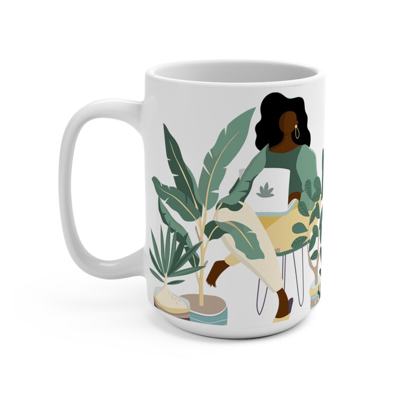 May include: White ceramic mug with a colorful illustration of a person sitting in a chair surrounded by plants. The person is wearing a green shirt and has long black hair. The plants are green and yellow.