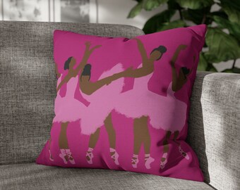 Puede incluir: Cojín de tiro rosa con un diseño gráfico de cuatro bailarinas en tutús rosas. Las bailarinas son todas negras y tienen piel morena.