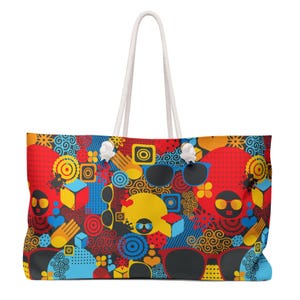 May include: A large tote bag with a vibrant, colorful pattern featuring sunglasses, geometric shapes, and abstract designs in red, yellow, blue, and black. The bag has white rope handles.
