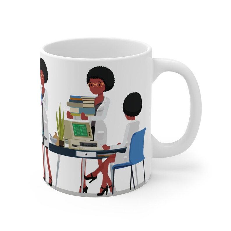 K&ouml;nnte beinhalten: Wei&szlig;e Keramiktasse mit einer bunten Illustration von drei Frauen in Laborkitteln. Die Frauen arbeiten an einem Schreibtisch mit einem Computer und B&uuml;chern. Die Tasse hat einen schwarzen Henkel.