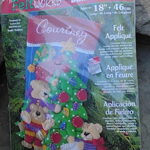 May include: Felt applique Christmas stocking kit with a Christmas tree design and three teddy bears. The kit includes wool yarn, cotton thread, printed felt, beads, sequins, and instructions. The stocking is approximately 18 inches (46 cm) long and features the name "Courtney".