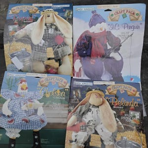 May include: Four craft kits featuring stuffed animal dolls. The kits include a rabbit named Rupert, a penguin named I.C., a chicken named Chelsea, and a bunny named Belinda. Each kit includes the doll and instructions.