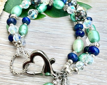 May include: A double-strand bracelet with green, blue, and clear beads. The bracelet has a heart-shaped clasp and a starfish charm.