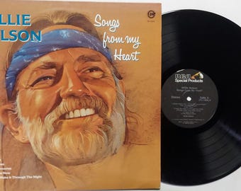 May include: Vintage vinyl record album by Willie Nelson, titled "Songs from my Heart." The album cover features a portrait of Willie Nelson with a blue bandana. The black vinyl record is visible on the right.