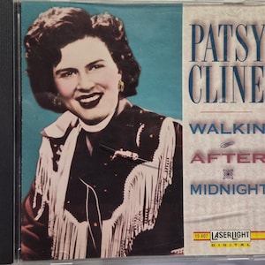 May include: A CD case featuring a portrait of Patsy Cline on a teal background. She wears a black jacket with white fringe. The text reads PATSY CLINE, WALKIN' AFTER MIDNIGHT, and LASERLIGHT DIGITAL. The case has a black spine and clear plastic cover.