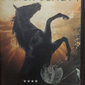 May include: A VHS tape for the movie "Black Beauty" featuring a black horse rearing up. The title is in large green letters, with the Warner Bros. logo at the top. The cover also includes text that reads "The most imaginative and stirring picture since The Black Stallion."