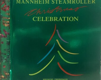 May include: A CD case with a green cover featuring the text "Mannheim Steamroller Christmas Celebration." A colorful Christmas tree design is below the title. The American Gramaphone logo is at the bottom.