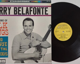 May include: A vintage vinyl record album cover featuring Harry Belafonte holding a guitar. The album title is "An Evening of Folk Songs and Calypso with the Islanders".