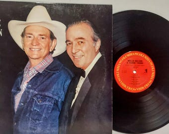 May include: A vinyl record album cover featuring Willie Nelson and Faron Young. The cover is black and white and features a photo of the two country music singers. The album title is "Funny How Time Slips Away".