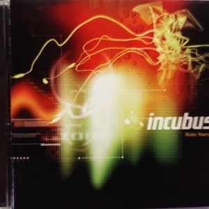 May include: A CD cover with a bright, abstract design featuring swirling lines of red, yellow, and green. The band name "Incubus" is written in white with the album title "Make Yourself" below it.