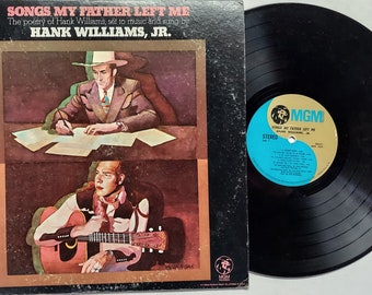 May include: Vintage vinyl record album cover for "Songs My Father Left Me" by Hank Williams, Jr. The cover art features illustrations of a man writing and playing guitar. The record itself is black with a blue and gold label.