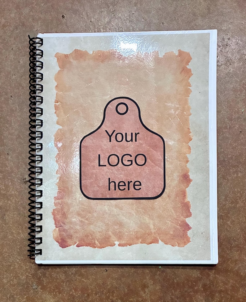 May include: A spiral-bound notebook with a light beige cover featuring a central rectangular graphic with torn edges in a reddish-brown hue. The graphic contains a black-outlined tag shape with the text Your LOGO here printed in black.